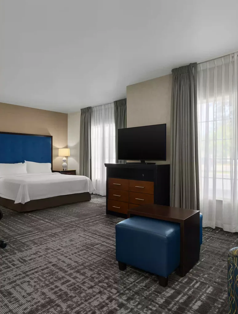 Hotel guest room with a neatly made king bed and bedside lamps