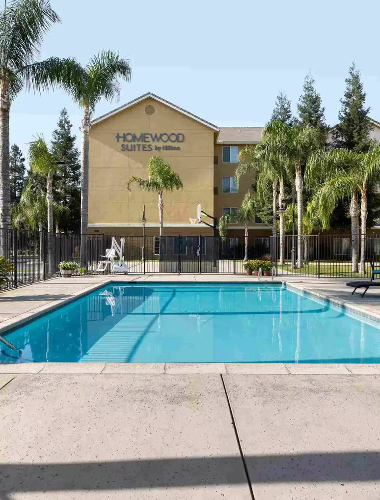 Homewood Suites exterior at dusk with lit windows and palm trees