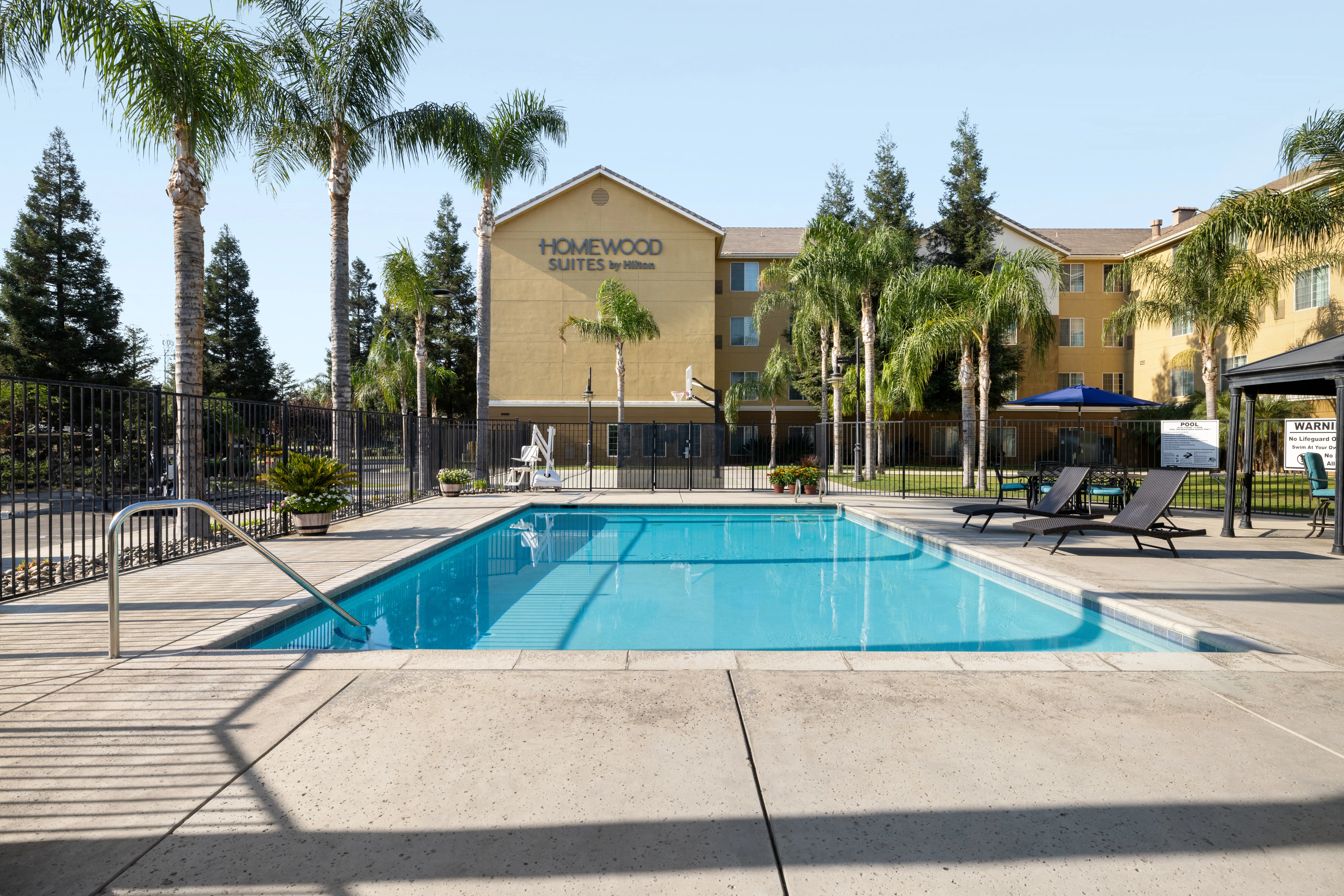 Homewood Suites exterior at dusk with lit windows and palm trees